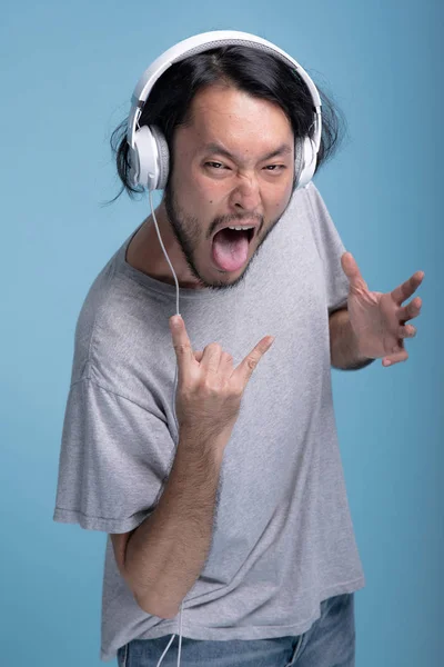 Ung Skäggig Man Lyssnar Musik Blå Bakgrund Asiatiska Unga Hipster — Stockfoto