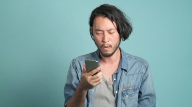 odaklı smartphone kullanarak, cebinden para alarak ve gadget'ı koyarak Genç Asyalı adam
