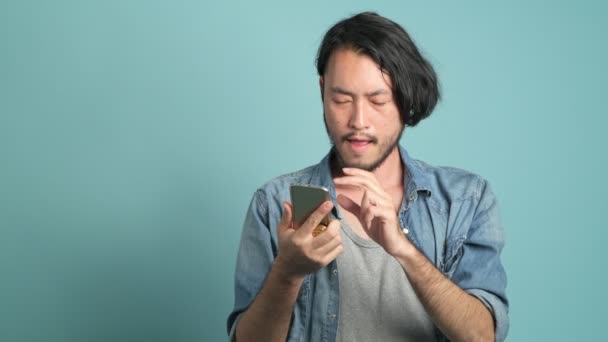 Atencioso Asiático Homem Usando Smartphone Assistindo Caindo Moedas — Vídeo de Stock