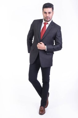 Beyaz arka planda izole iş adamı. Takım elbise portre, yakışıklı genç Hintli işadamı eller cebinde görünüyor. Tam uzunlukta vurdu.