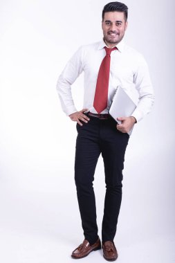 İzole iş adamı. Yakışıklı genç Hintli işadamı dizüstü portre ile kendine güvenen gülümseme görünüyor. Tam uzunlukta vurdu.