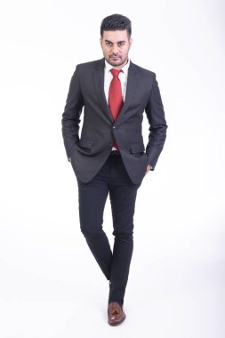 Beyaz arka planda izole iş adamı. Takım elbise portre, yakışıklı genç Hintli işadamı eller cebinde görünüyor. Tam uzunlukta vurdu.