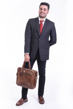 Beyaz arka planda izole iş adamı. Yakışıklı genç Hintli işadamı çanta portre ile takım elbiseli, eller arkasına görünüyor. Tam uzunlukta vurdu.