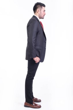 Beyaz arka planda izole iş adamı. Takım elbise portre yakışıklı genç Hintli işadamı, elleri ceplerinde görünüyor. Tam uzunlukta yan vurdu.