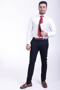 İzole iş adamı. Yakışıklı genç Hintli işadamı ile dizüstü portre, kendinden emin görünüyor. Tam uzunlukta vurdu.