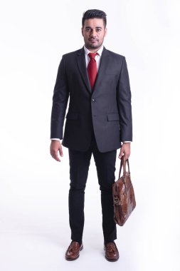 Beyaz arka planda izole iş adamı. Yakışıklı genç Hintli işadamı takım ile çanta portre, kendinden emin görünüyor. Tam uzunlukta vurdu.