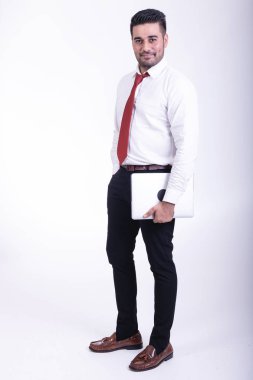 İzole iş adamı. Yakışıklı genç Hintli işadamı ile dizüstü portre, kendinden emin görünüyor. Tam uzunlukta vurdu.