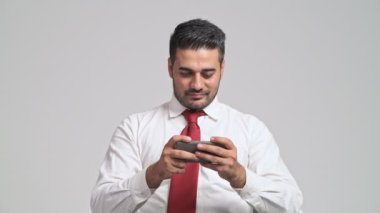 odaklı smartphone üzerinde video oyun oynarken ve gülümseyen genç adam