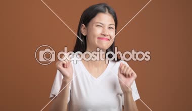 Genç kadın izole dans. Asyalı kadın komik dans turuncu arka plan üzerinde beyaz t-shirt.