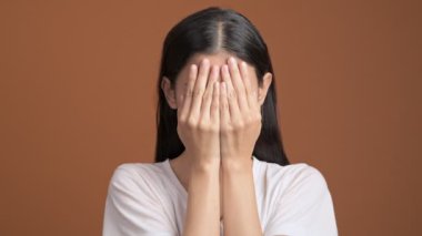 ellerini arkasına saklanarak ve sonra gülümseyerek Asyalı kadın 