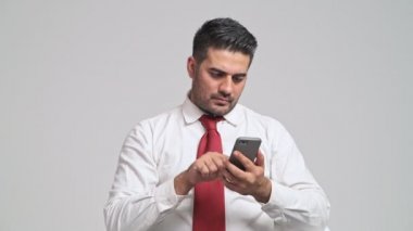 özenli genç adam akıllı telefon ve şok olma kullanarak