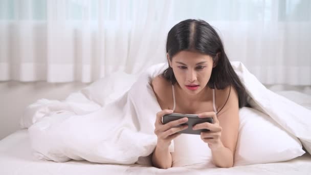 Mulher Jogando Jogo Móvel Cama Mulher Asiática Usando Telefone Celular — Vídeo de Stock