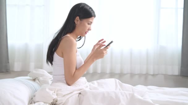 Mujer Comprando Cama Mujer Asiática Usando Teléfono Móvil Sentado Cama — Vídeos de Stock