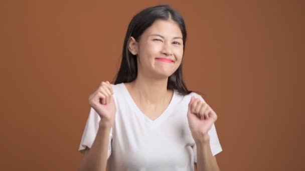 查出的年轻女子跳舞 在白色 T恤跳舞滑稽的亚洲妇女在橙色背景 — 图库视频影像