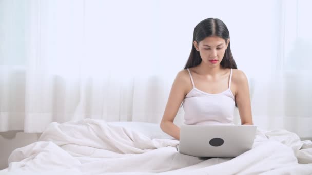 Chocado Repugnado Jovem Asiático Mulher Sentado Cama Usando Laptop — Vídeo de Stock