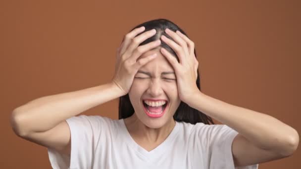 Asian Woman Screaming Holding Hands Head Brown Background — Stock Video