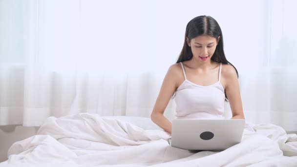 Yatakta Oturmuş Dizüstü Bilgisayar Kullanarak Sürpriz Genç Asyalı Kadın — Stok video