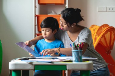 Çocuk ev ödevi. Genç karışık yarış çocuk teras ev ödevi. Annesiyle birlikte kitap okumak. Odak ruh. Geri okul kavramı.