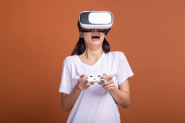 Kadın giyiyor Vr kulaklık. Poz şok edici beyaz t-shirt ile Vr kafa dişli, Genç Asyalı kadın. Yeni eğlence kavramının.