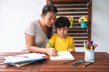 Çocuk ev ödevi. Genç karışık yarış çocuk ödev Teras evde annesiyle vermiyorsun. Uygulama yazma. Odak ruh. Geri okul kavramı.