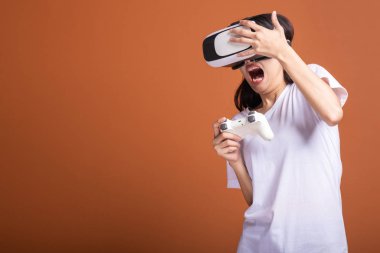 Kadın giyiyor Vr kulaklık. Korkutma poz şok edici beyaz t-shirt ile Vr kafa dişli, Genç Asyalı kadın. Yeni eğlence kavramının.