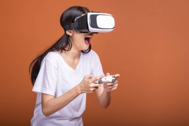 Kadın giyiyor Vr kulaklık. Genç Asyalı kadın Vr kafa dişli, çok beyaz tişört içinde poz heyecanlı. Yeni eğlence kavramının.