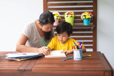 Çocuk ev ödevi. Genç karışık yarış çocuk ödev Teras evde annesiyle vermiyorsun. Uygulama yazma. Odak ruh. Geri okul kavramı.