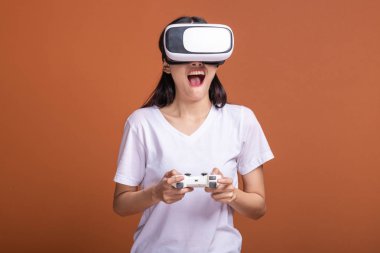 Kadın giyiyor Vr kulaklık. Poz şok edici beyaz t-shirt ile Vr kafa dişli, Genç Asyalı kadın. Yeni eğlence kavramının.