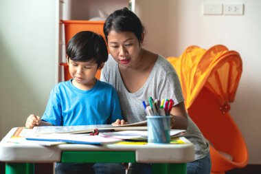 Çocuk ev ödevi. Genç karışık yarış çocuk teras ev ödevi. Annesiyle birlikte kitap okumak. Odak ruh. Geri okul kavramı.