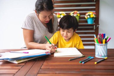 Çocuk ev ödevi. Genç karışık yarış çocuk ödev Teras evde annesiyle vermiyorsun. Uygulama yazma. Mutlu ruh hali. Geri okul kavramı.