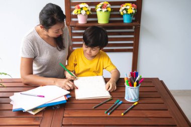 Çocuk ev ödevi. Genç karışık yarış çocuk ödev Teras evde annesiyle vermiyorsun. Uygulama yazma. Mutlu ruh hali. Geri okul kavramı.