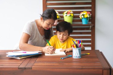 Çocuk ev ödevi. Genç karışık yarış çocuk ödev Teras evde annesiyle vermiyorsun. Uygulama yazma. Odak ruh. Geri okul kavramı.