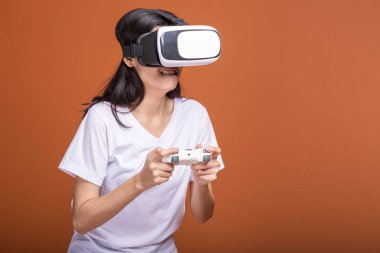 Kadın giyiyor Vr kulaklık. Kameraya bakarak beyaz t-shirt ile Vr kafa dişli, Genç Asyalı kadın. Yeni eğlence kavramının.