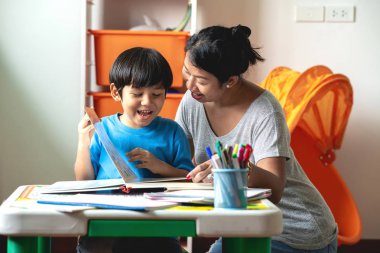 Çocuk ev ödevi. Genç karışık yarış çocuk teras ev ödevi. Annesiyle birlikte kitap okumak. Mutlu ruh hali. Geri okul kavramı.