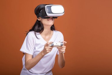 Kadın giyiyor Vr kulaklık. Poz şok edici beyaz t-shirt ile Vr kafa dişli, Genç Asyalı kadın. Yeni eğlence kavramının.