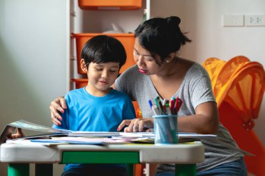 Çocuk ev ödevi. Genç karışık yarış çocuk teras ev ödevi. Annesiyle birlikte kitap okumak. Mutlu ruh hali. Geri okul kavramı.
