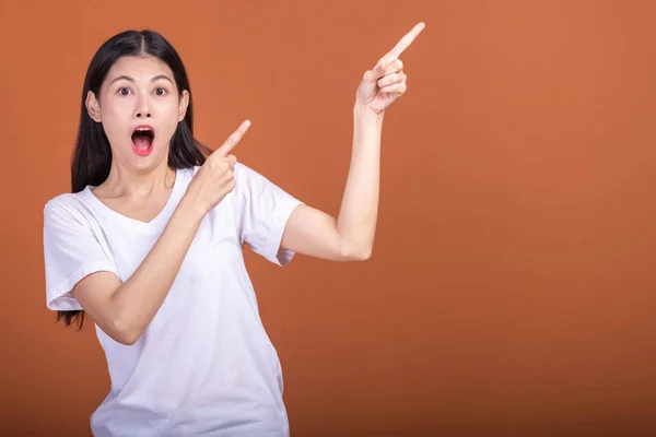 一个惊喜的女人超过橙色背景 年轻的亚洲时髦女人穿着白色 带着非常震撼的姿势 手指指着 年轻妇女时髦概念 — 图库照片