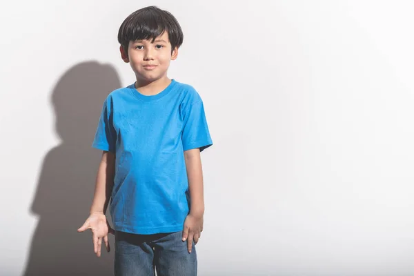 年轻的男孩肖像在白色背景与硬光 混合的种族男孩在蓝色衬衣和吉恩 — 图库照片