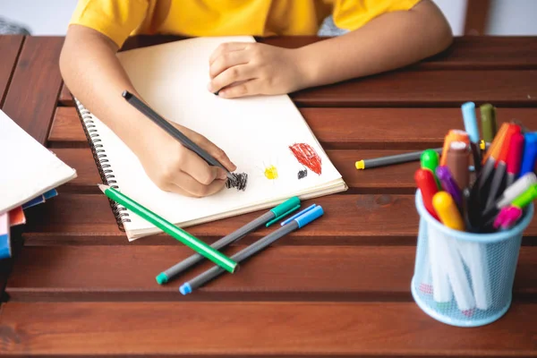 儿童作业 年轻的混血男孩在家的露台做作业 绘制着色 集中心情 返回学校概念 — 图库照片