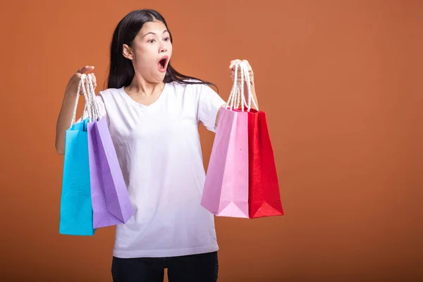 Mujer Sosteniendo Bolsa Aislada Fondo Naranja Mujer Asiática Joven Camiseta —  Fotos de Stock