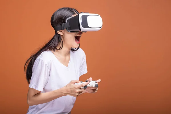 Woman wearing VR headset. Young Asian woman in white t-shirt with VR head gear, shocking pose. New entertainment concept.