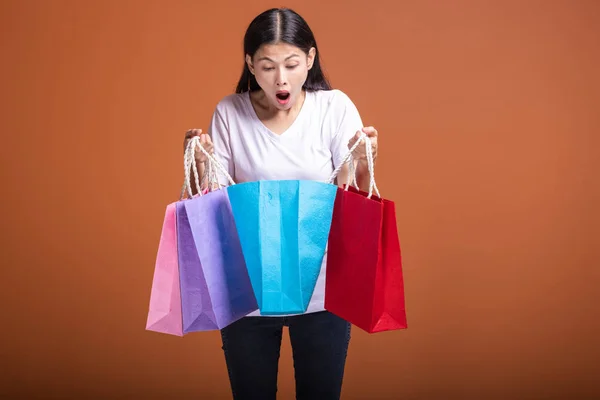 Mujer Sosteniendo Bolsa Aislada Fondo Naranja Mujer Asiática Joven Camiseta — Foto de Stock