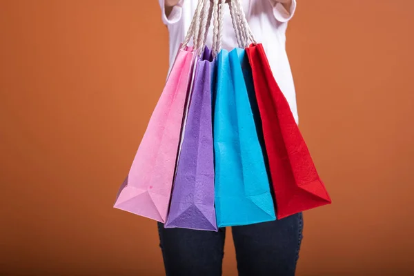 オレンジ色の背景で分離された買い物袋を持った女性 シャツ 幸せな気分で若いアジア女性 ショッピング概念 — ストック写真