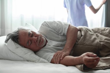 Komuta sizde uyku yatak ve hemşire perdeyi açın. Asya ihtiyar ve yatak odası ve açık perde kadında güzel Asyalı hemşire. Üst düzey hizmet kavramı. Atış kapatın.