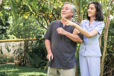 El rahatlatıcı. Genç tutan yaşlı adamın omuz açık bahçe hemşire. Üst düzey bakım, bakım alıcı ve üst düzey emeklilik ev hizmet anlayışı.