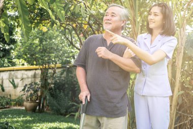 El rahatlatıcı. Genç tutan yaşlı adamın omuz açık bahçe hemşire. Üst düzey bakım, bakım alıcı ve üst düzey emeklilik ev hizmet anlayışı.