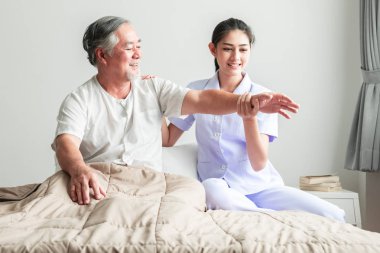 Komuta sizde üzerinde çalışan genç çekici fizyoterapist. Asya kıdemli adamın kolu ile çalışan güzel Asyalı kadın. Üst düzey ev bekçi hizmet anlayışı.
