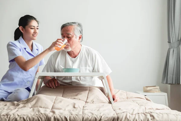 Jonge Aantrekkelijke Verpleegkundige Ontbijt Vervoederen Aan Senior Man Bed Oude — Stockfoto