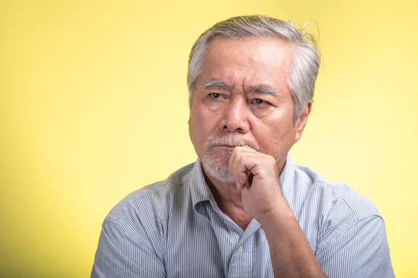 Senior man portrait isolated. Old asian man with white beard standing in front of camera, thinking. Senior lifestyle concept.