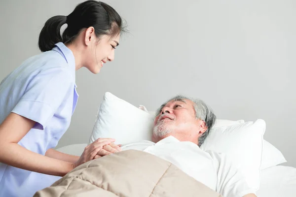 Senior man in bed having bed dream with nurse come in and calm him down. Old asian man and beautiful asian nurse woman in bedroom. Senior home service concept.